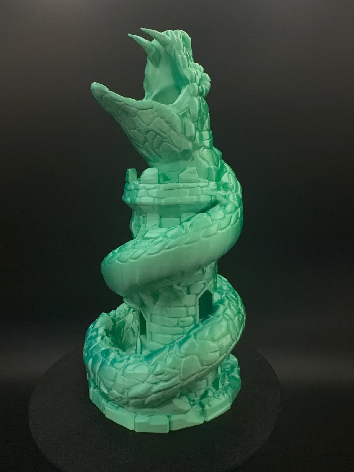 Side view of basilisk coiled around a stone tower