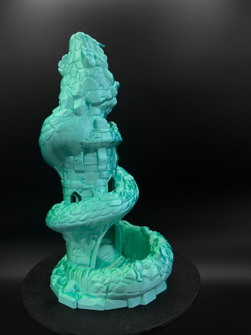 Rear view of scaled basilisk and stone tower