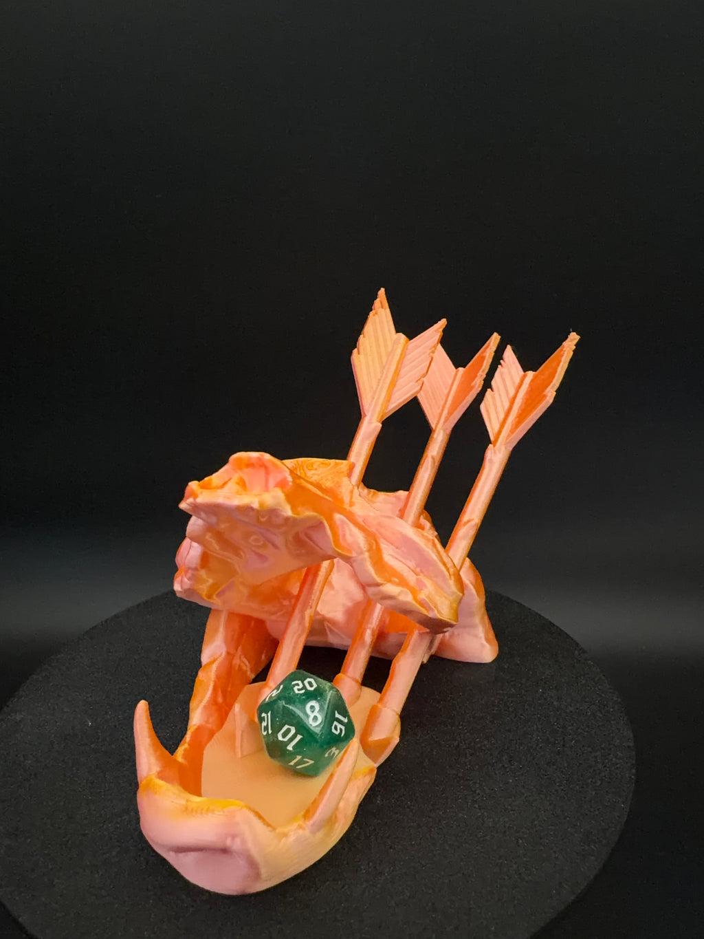 Front view of arrow-pierced skull dice tower in orange and pink