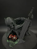 Front view of green and black hooded skeletal dice tower with sword