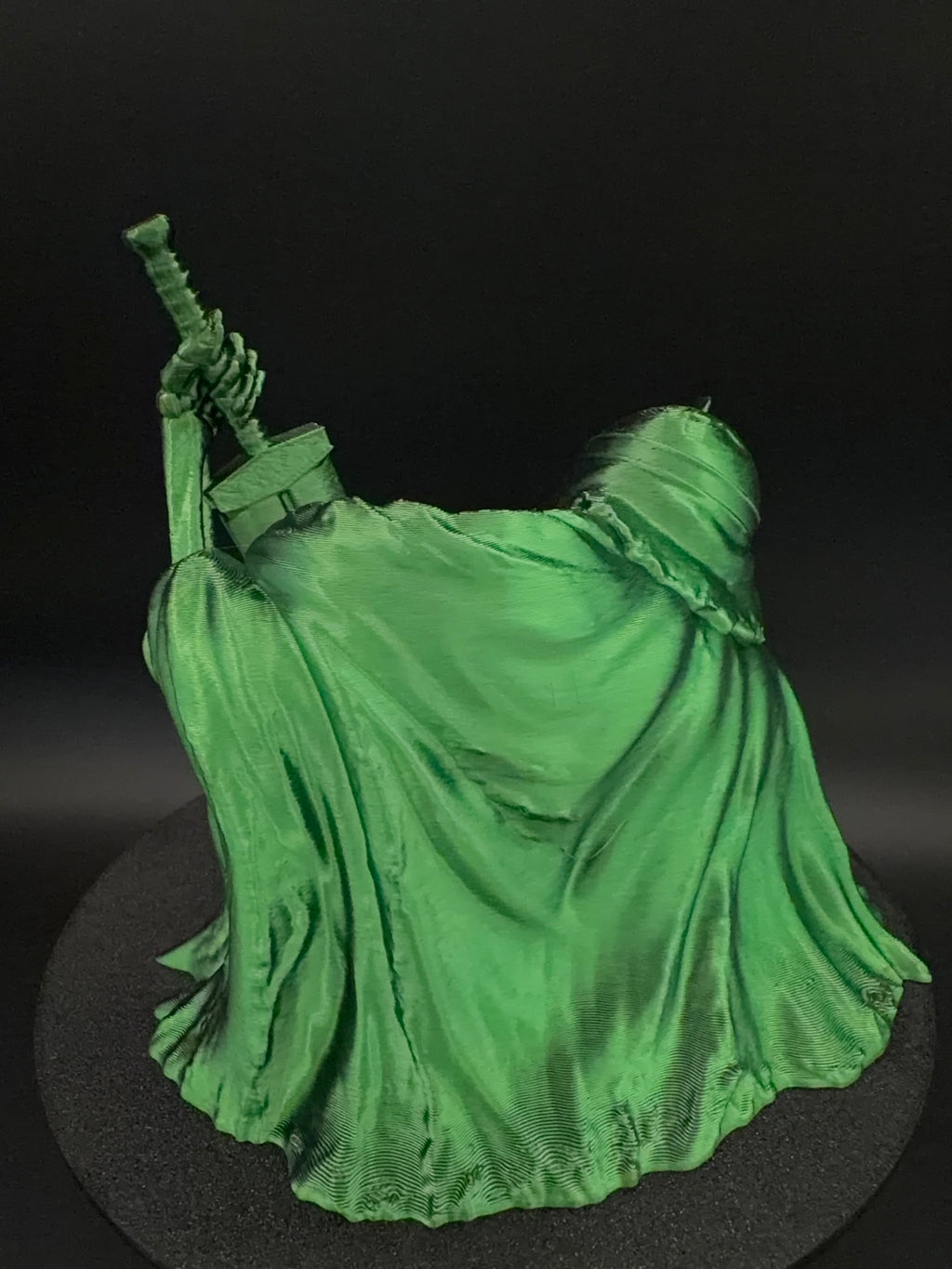 Back view of green cloak on skeletal dice tower