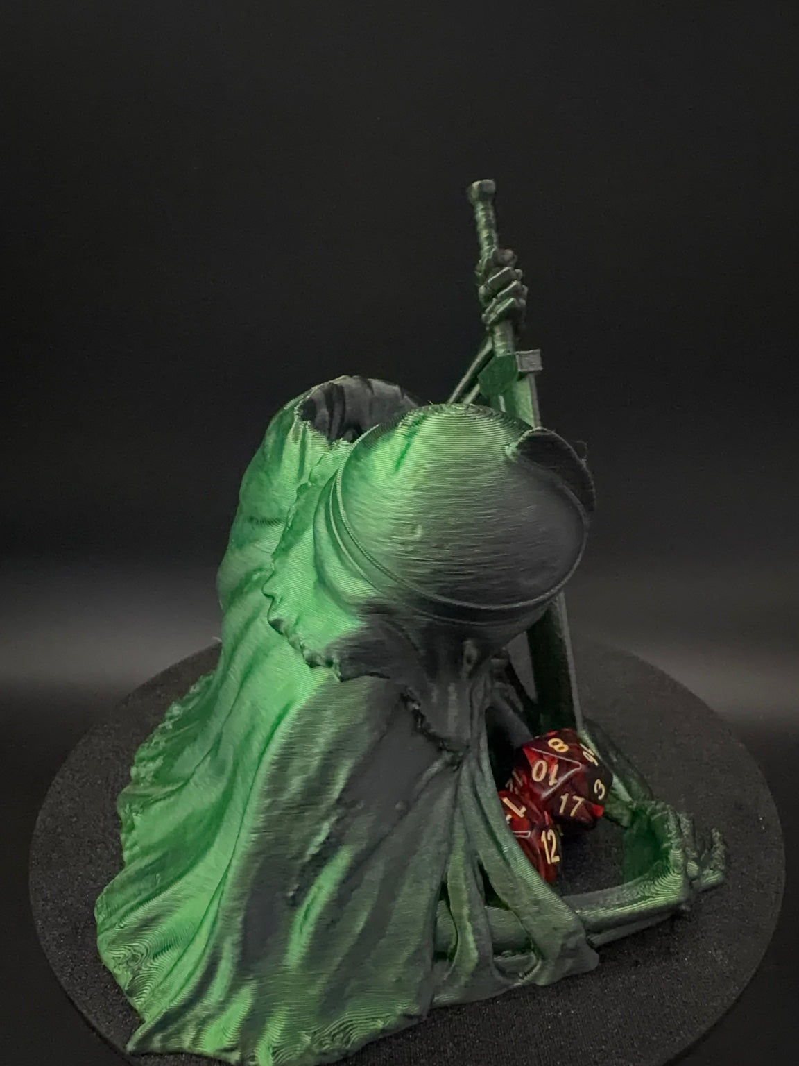 Opposite side view of hooded figure and dice tray