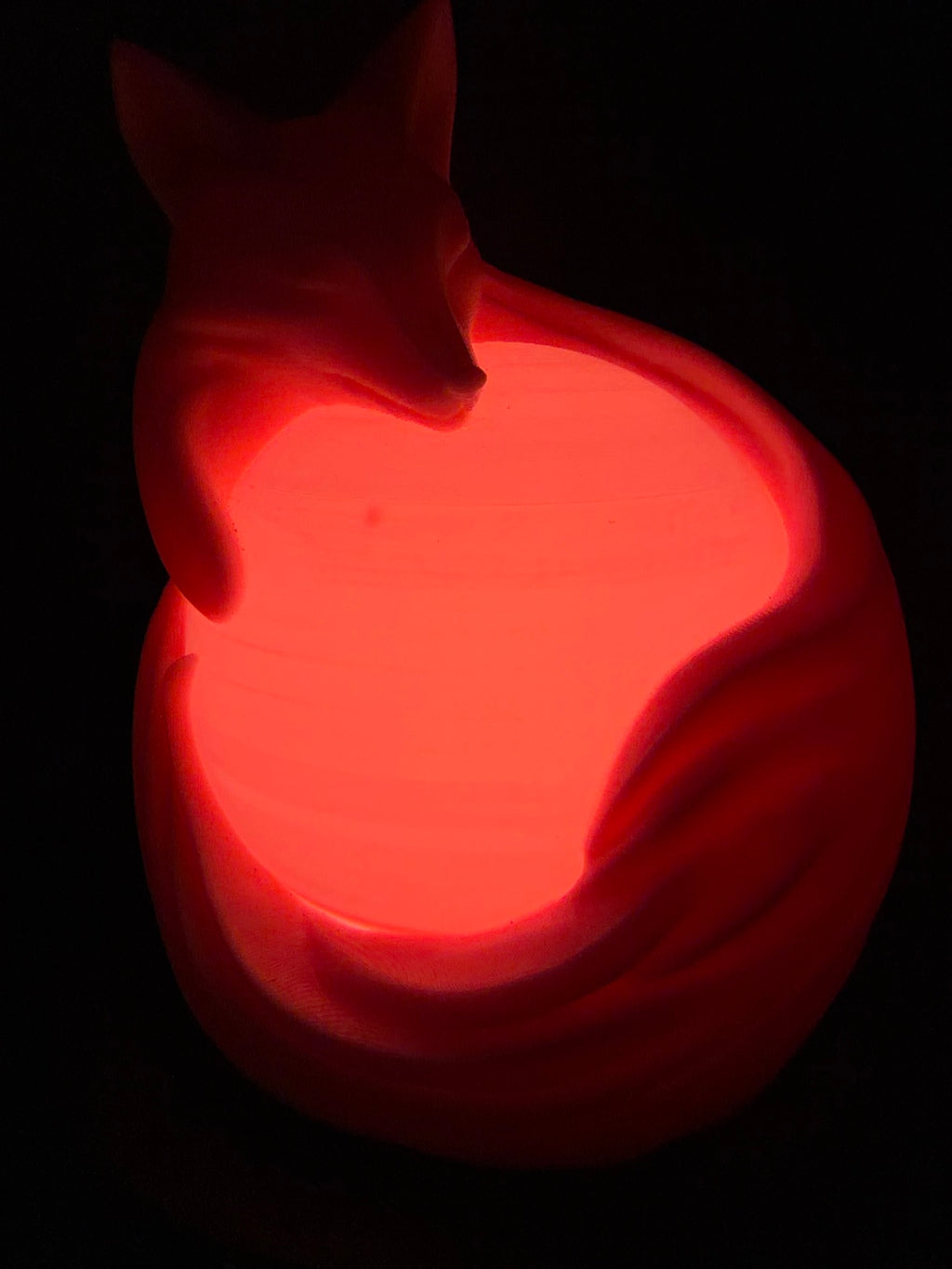 Pink fox LED lamp glowing red from the front