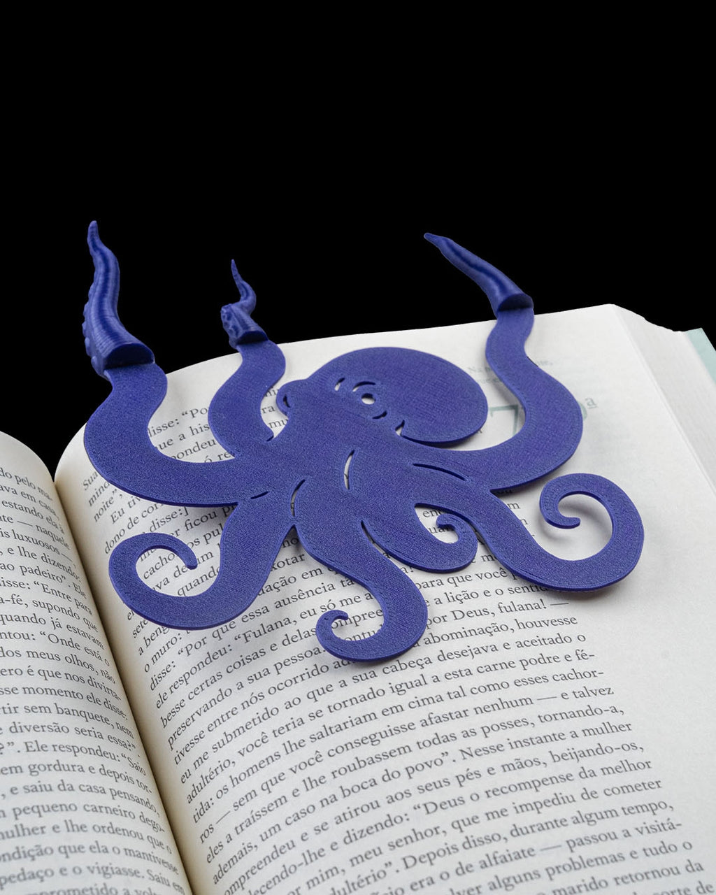 Blue collectible bookmark angled on an open book