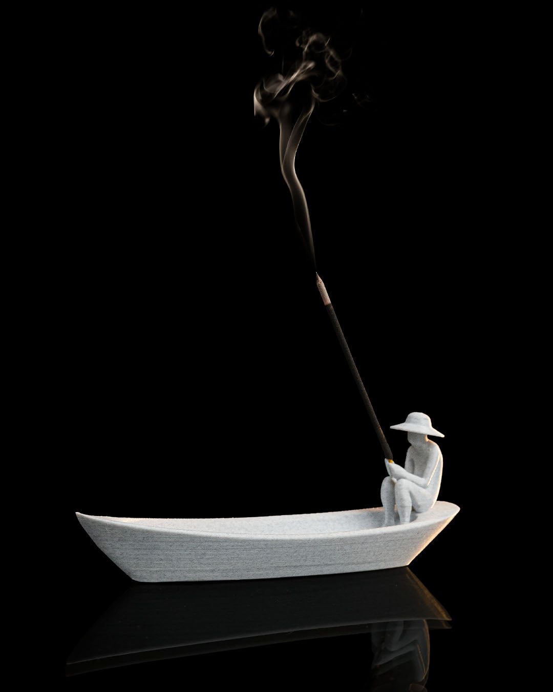 Still Waters incense holder with incense smoke rising from the seated figure in boat-shaped tray